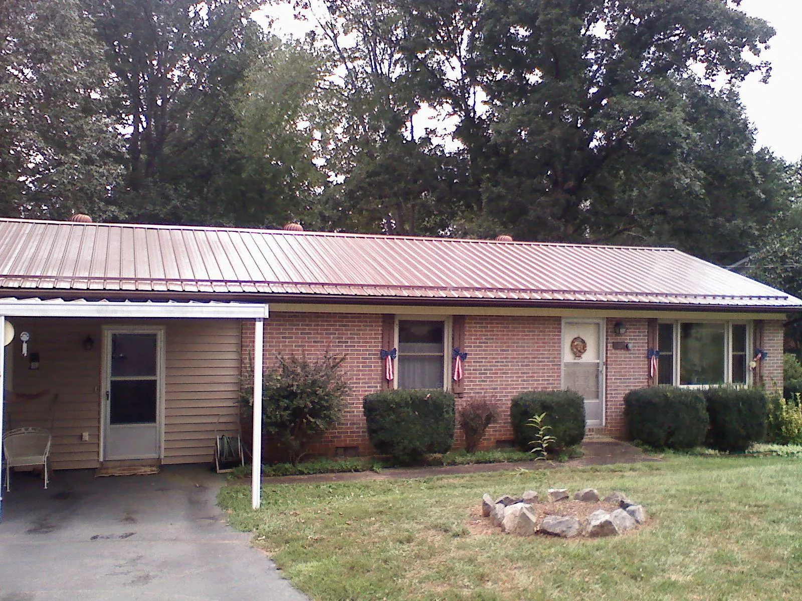 Bronze metal roof and carport on a brick ranch home — Roof Repair work by our crew in Mount Crawford